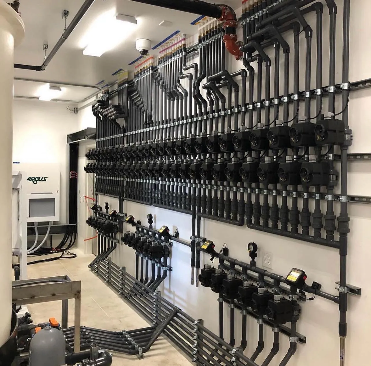 A distribution manifold wall with rows of actuated valves.