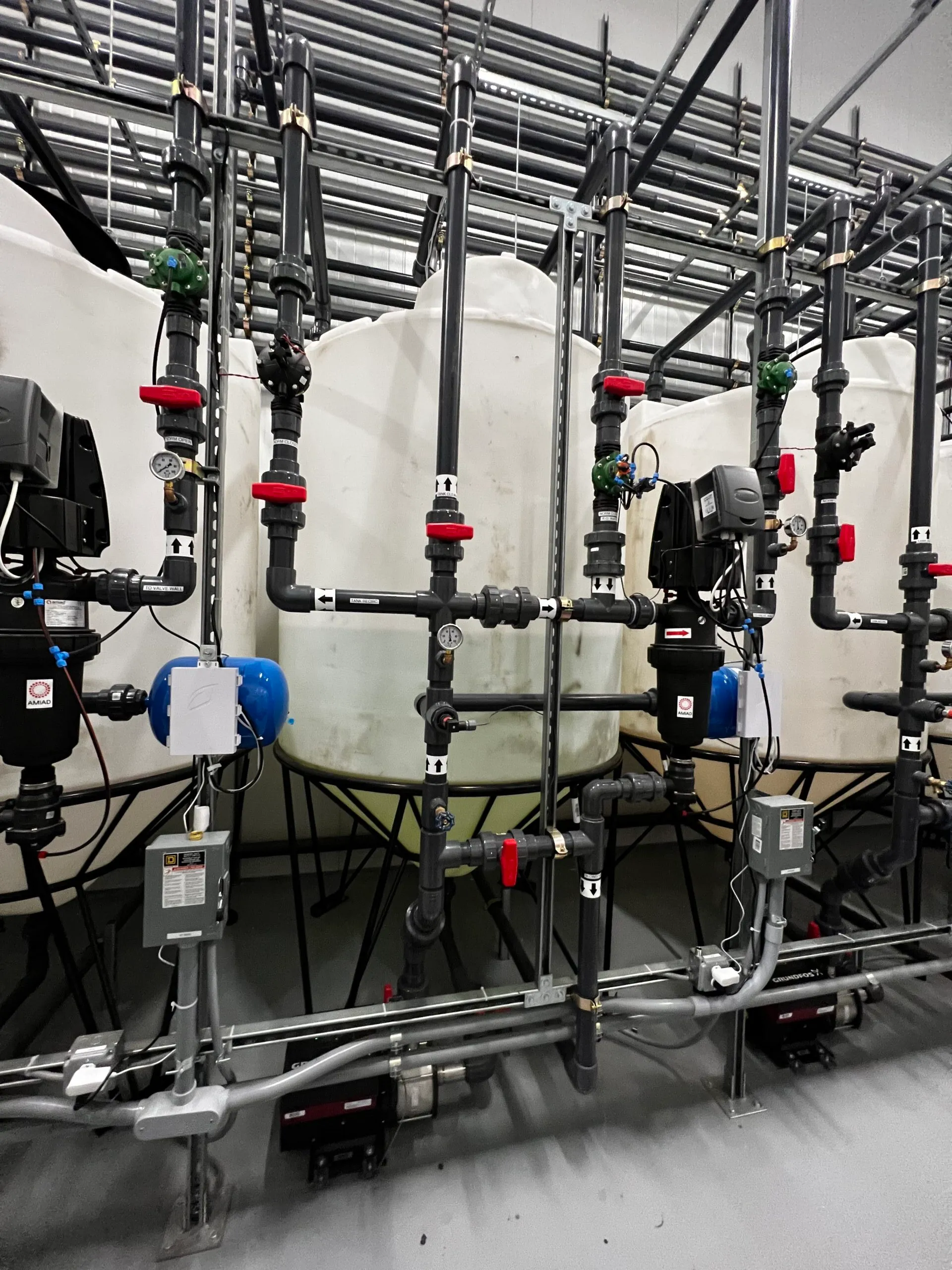 Tanks and pumps with gray process piping.